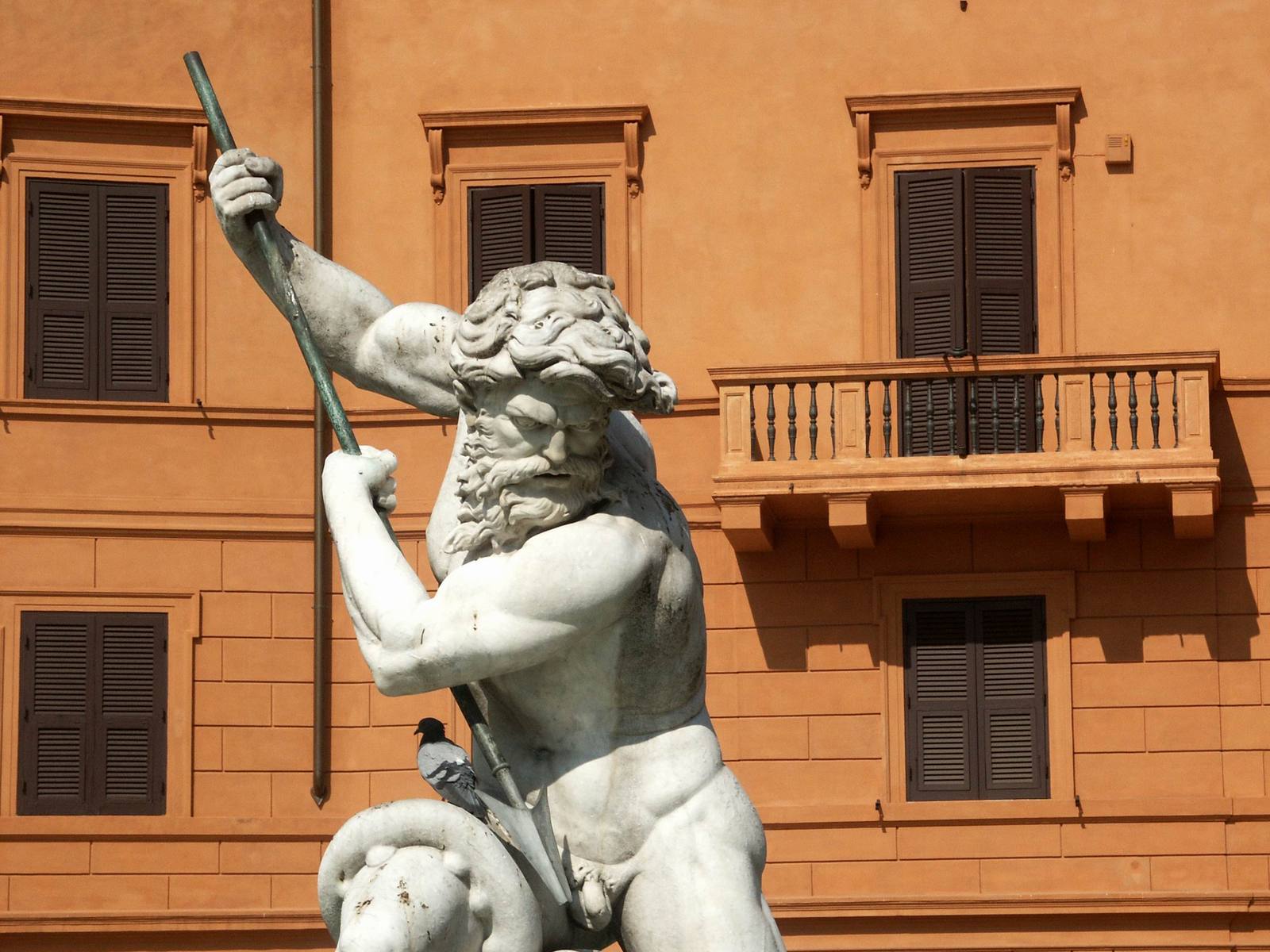 a statue of a man holding a hammer and walking next to a building