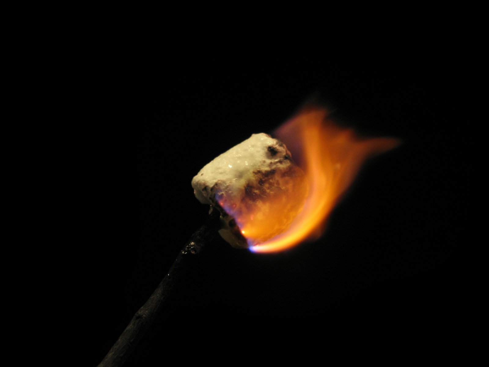 a flame is glowing on a stick in the dark