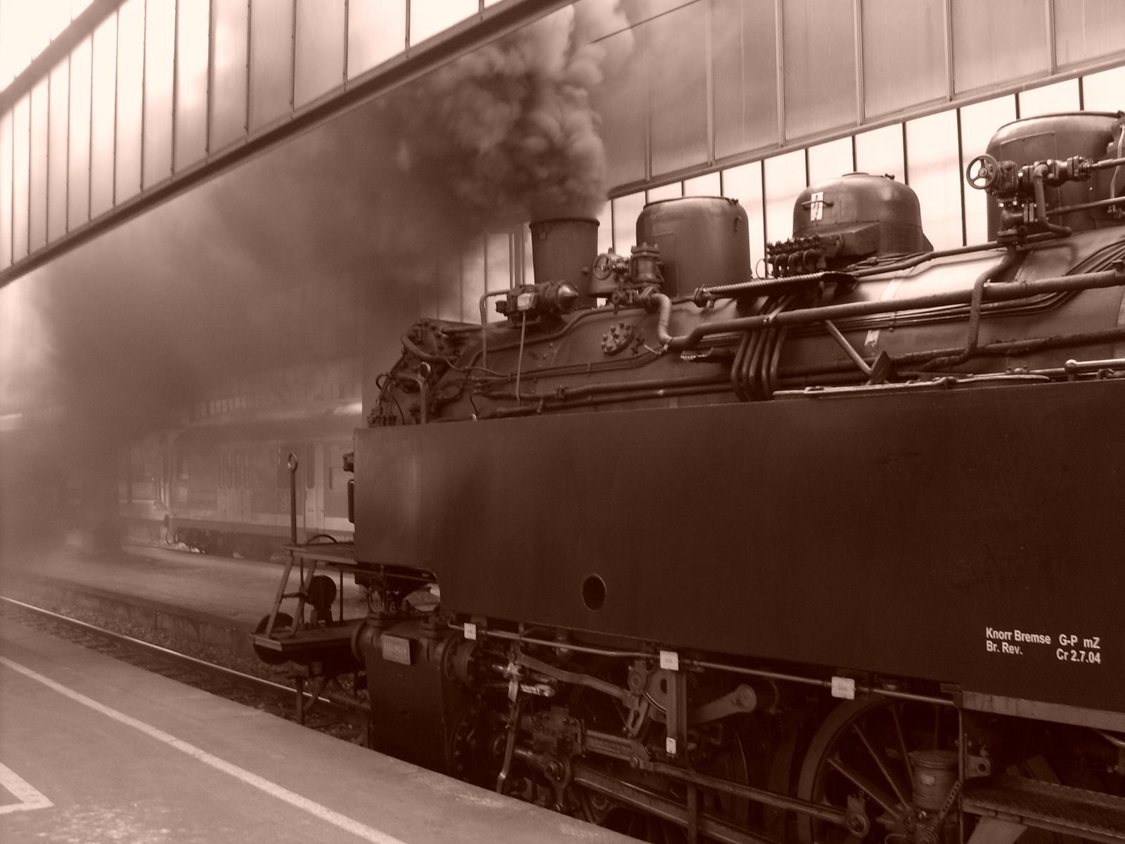 steam engine train leaving the station smoking at dusk