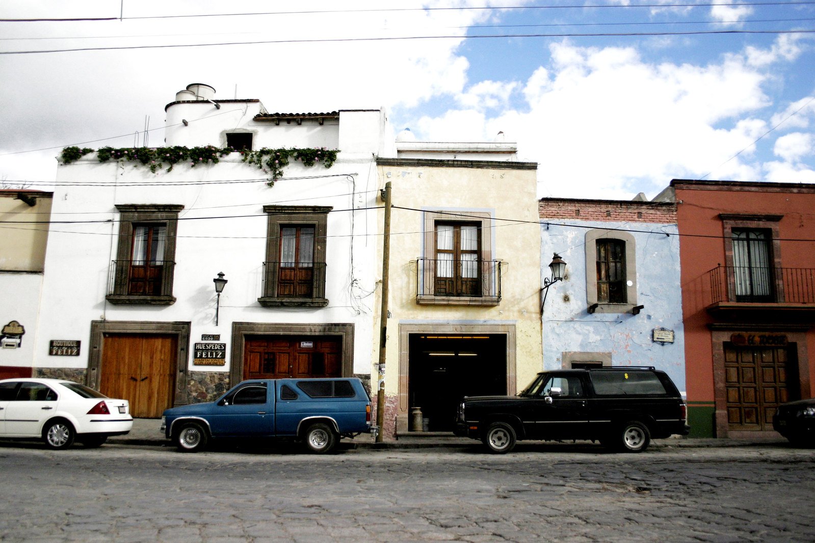 a couple cars parked on the side of a street