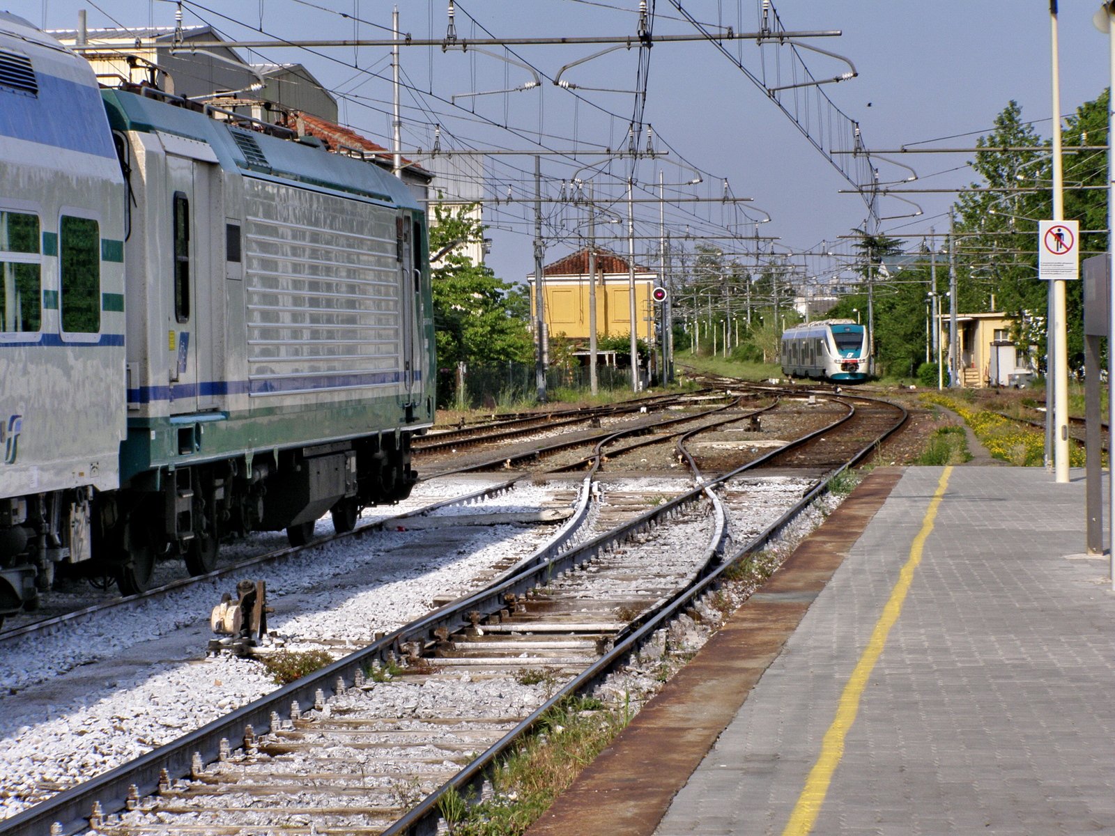 a train traveling down train tracks next to a loading platform