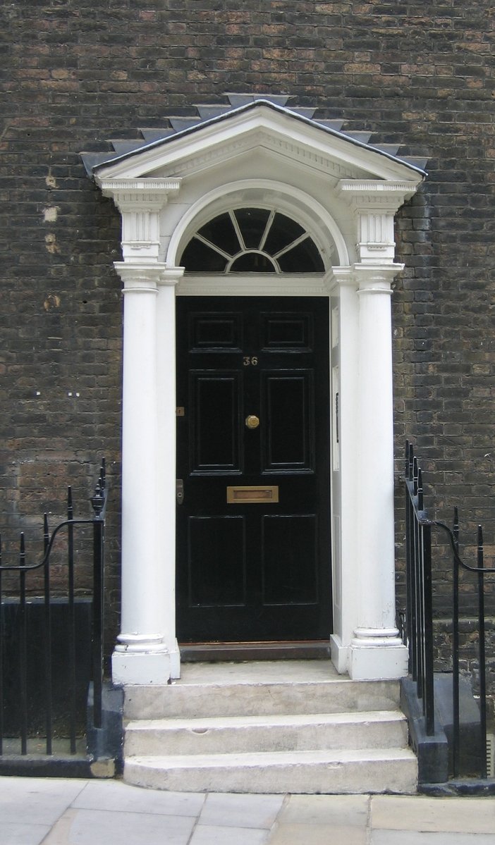 a door and pillars outside a dark colored building