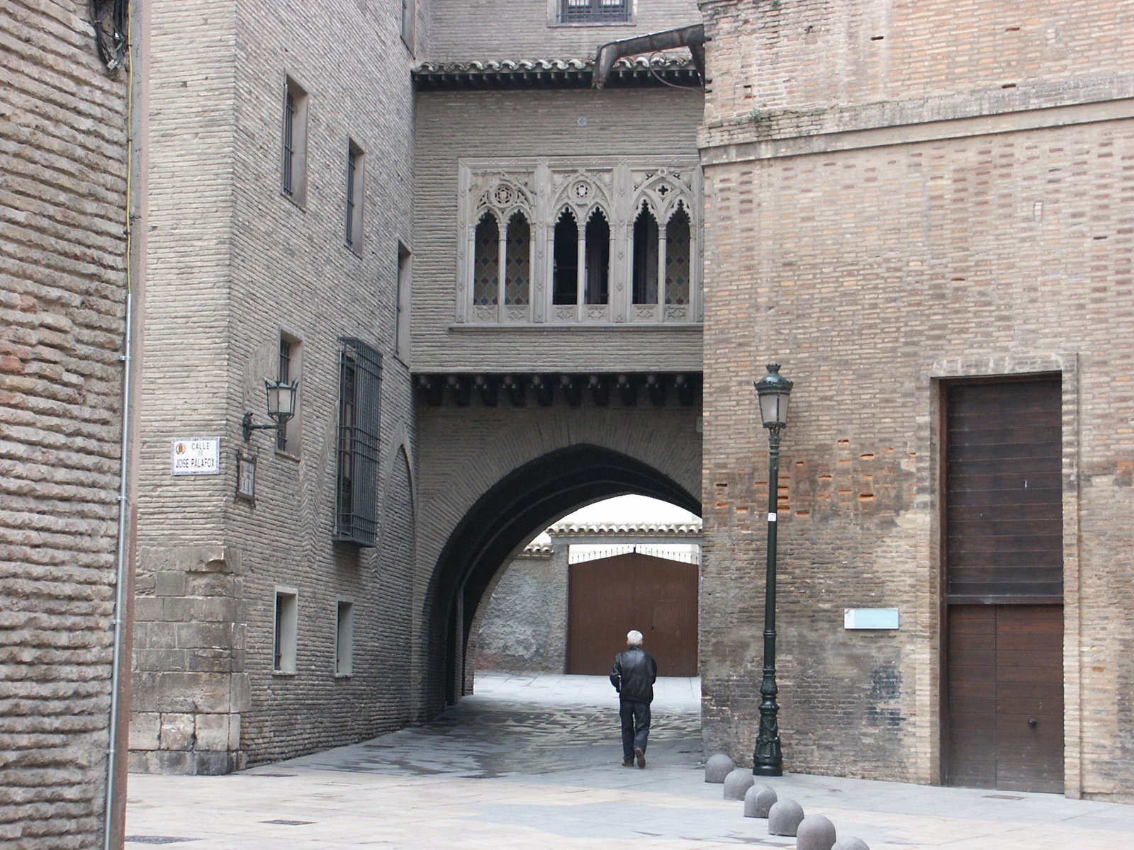 man walking through alley with arches leading up and down