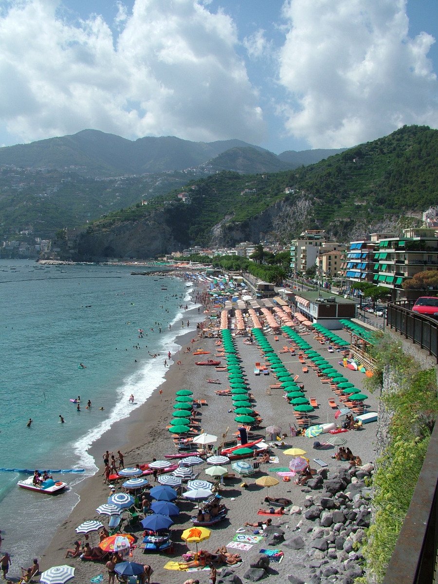 a crowded beach filled with people and umbrellas