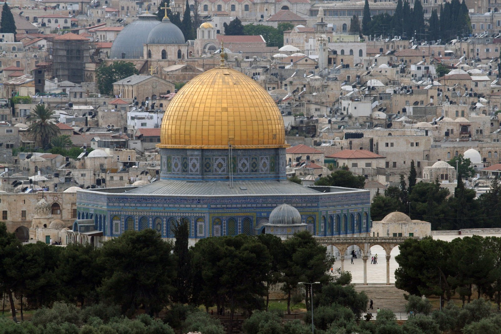 the dome of a mosque in israel sits in front of a small city