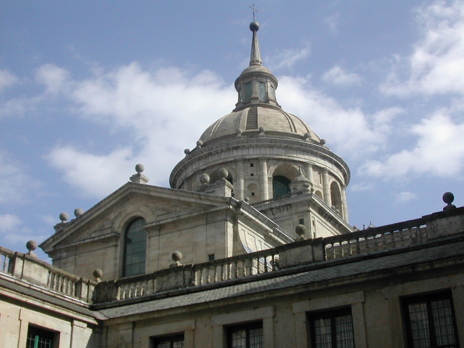 a large dome is behind the rooftops and top of a building