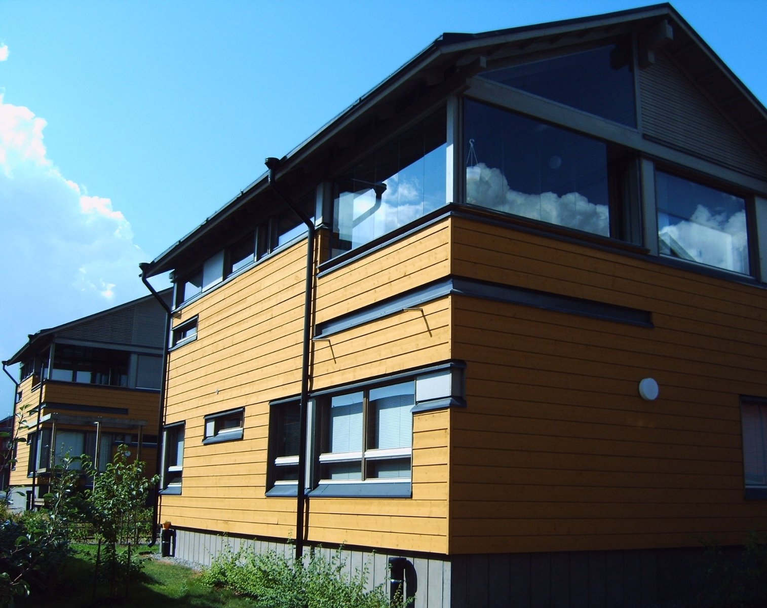 a tall yellow house sitting in the grass