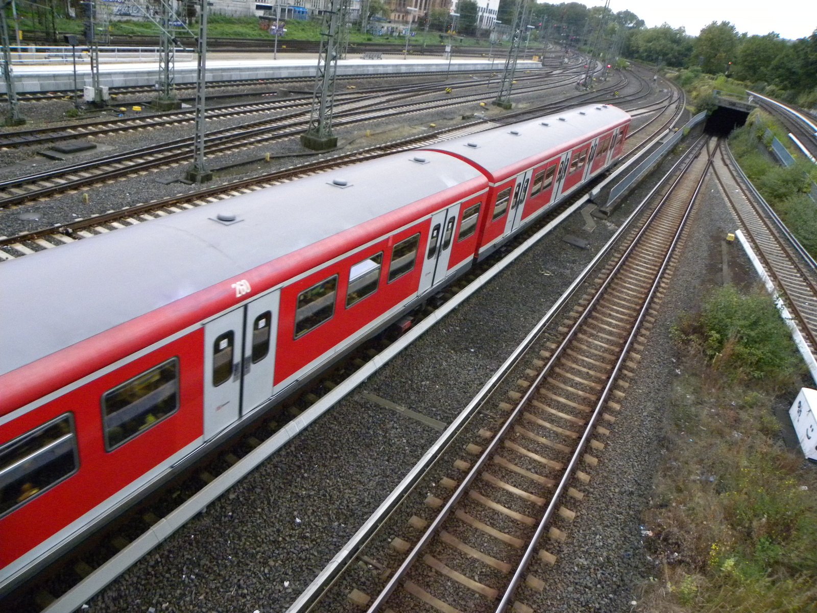 an extremely long red train traveling through the countryside