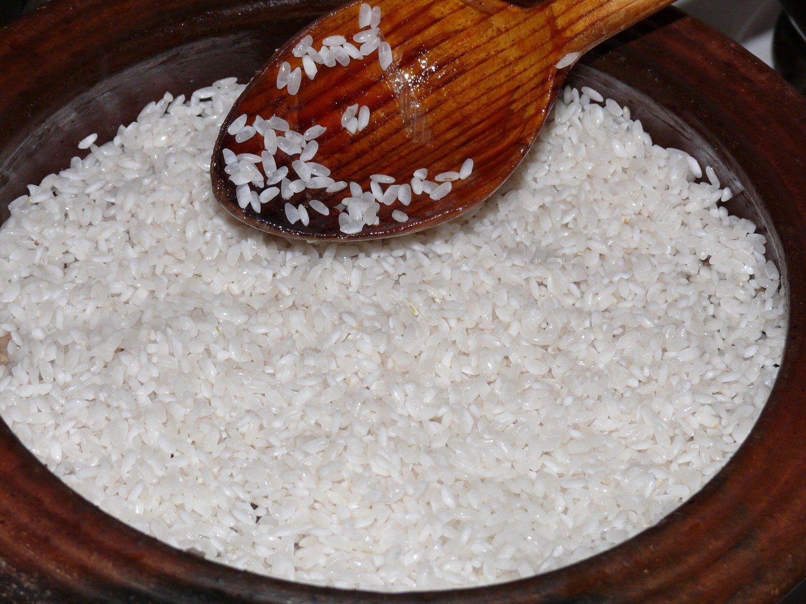 there is rice in a bowl with a spoon