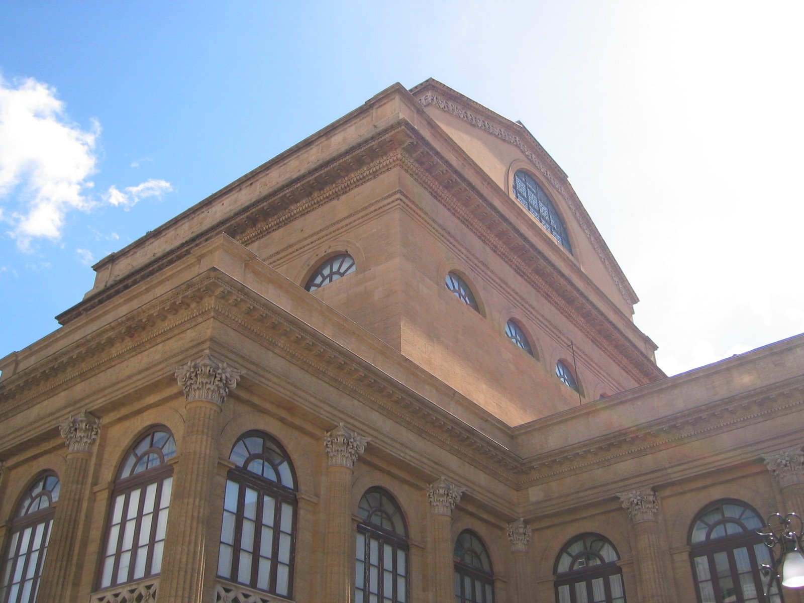 a tan building with many windows under a blue sky