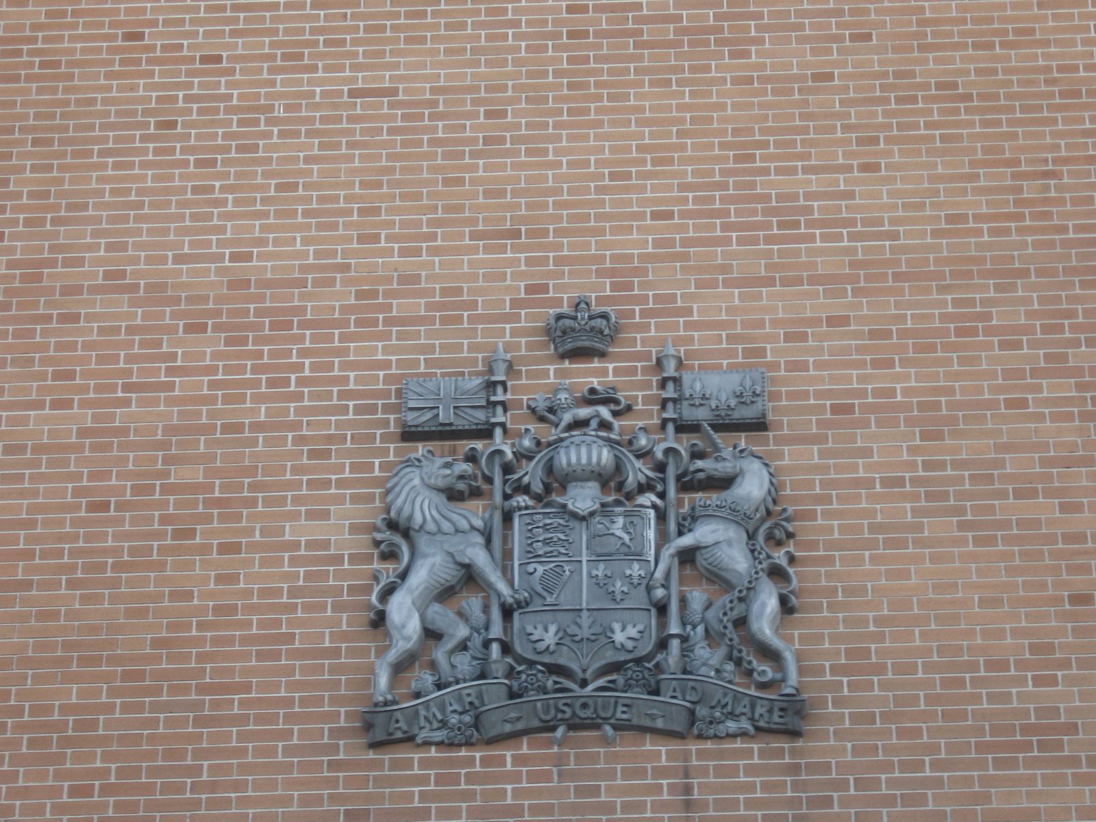 an ornate brick wall with a coat of arms and two lions