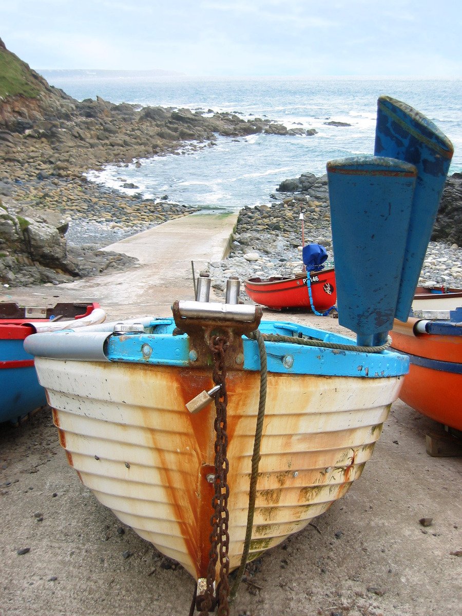 a row boat sitting on top of a beach