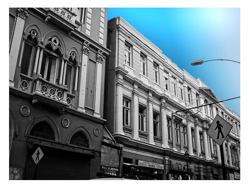 the buildings of a city street are lined up against the blue sky