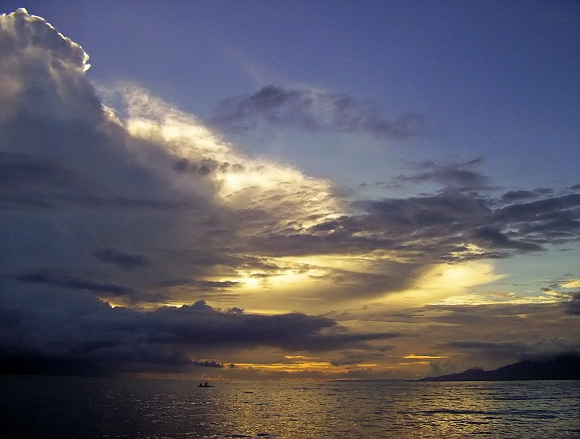 a boat in the ocean with the sun shining