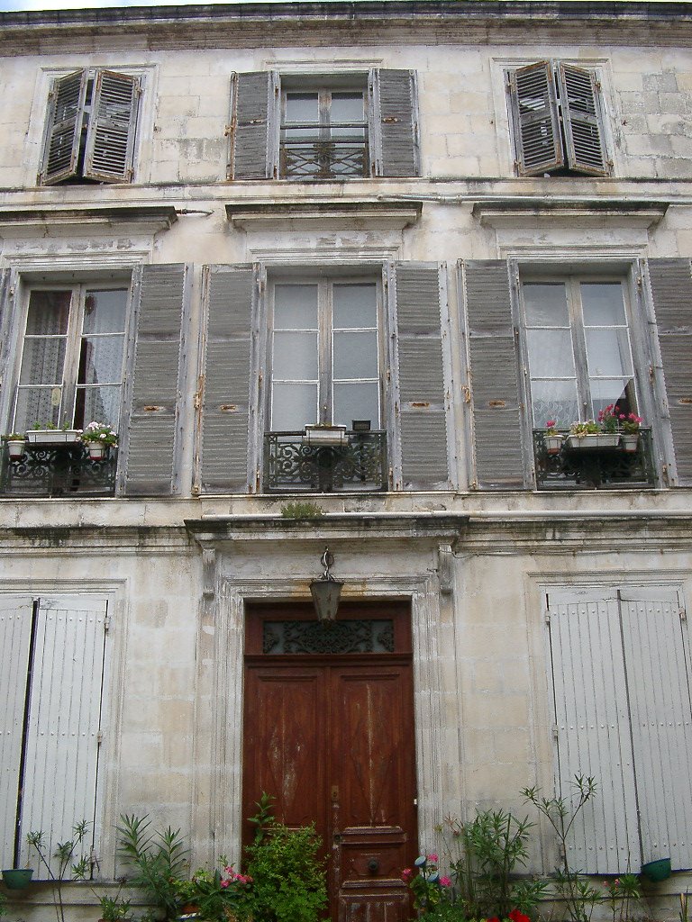 an old building has wooden shutters and white doors