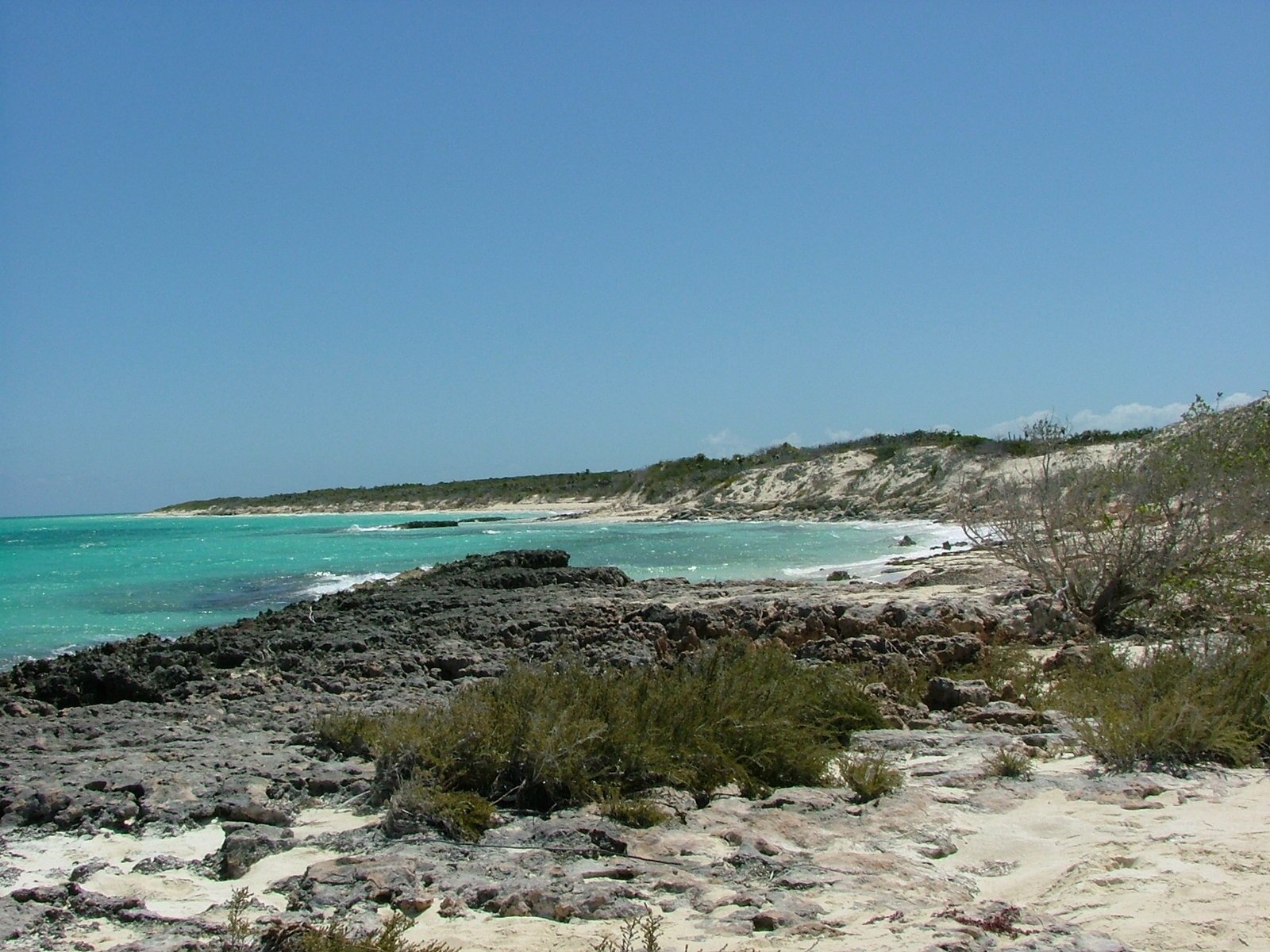 water and sand next to the ocean near an sandy shore