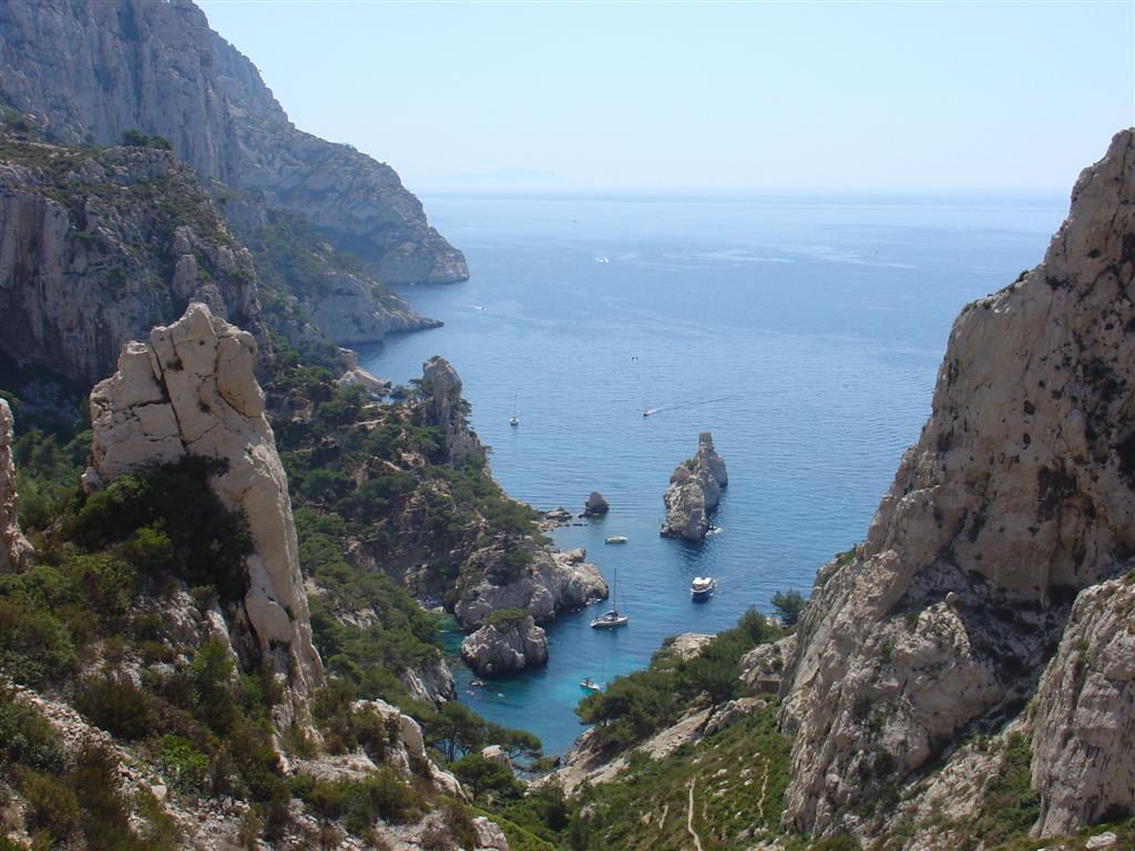 boats in the sea near rocky cliff formations