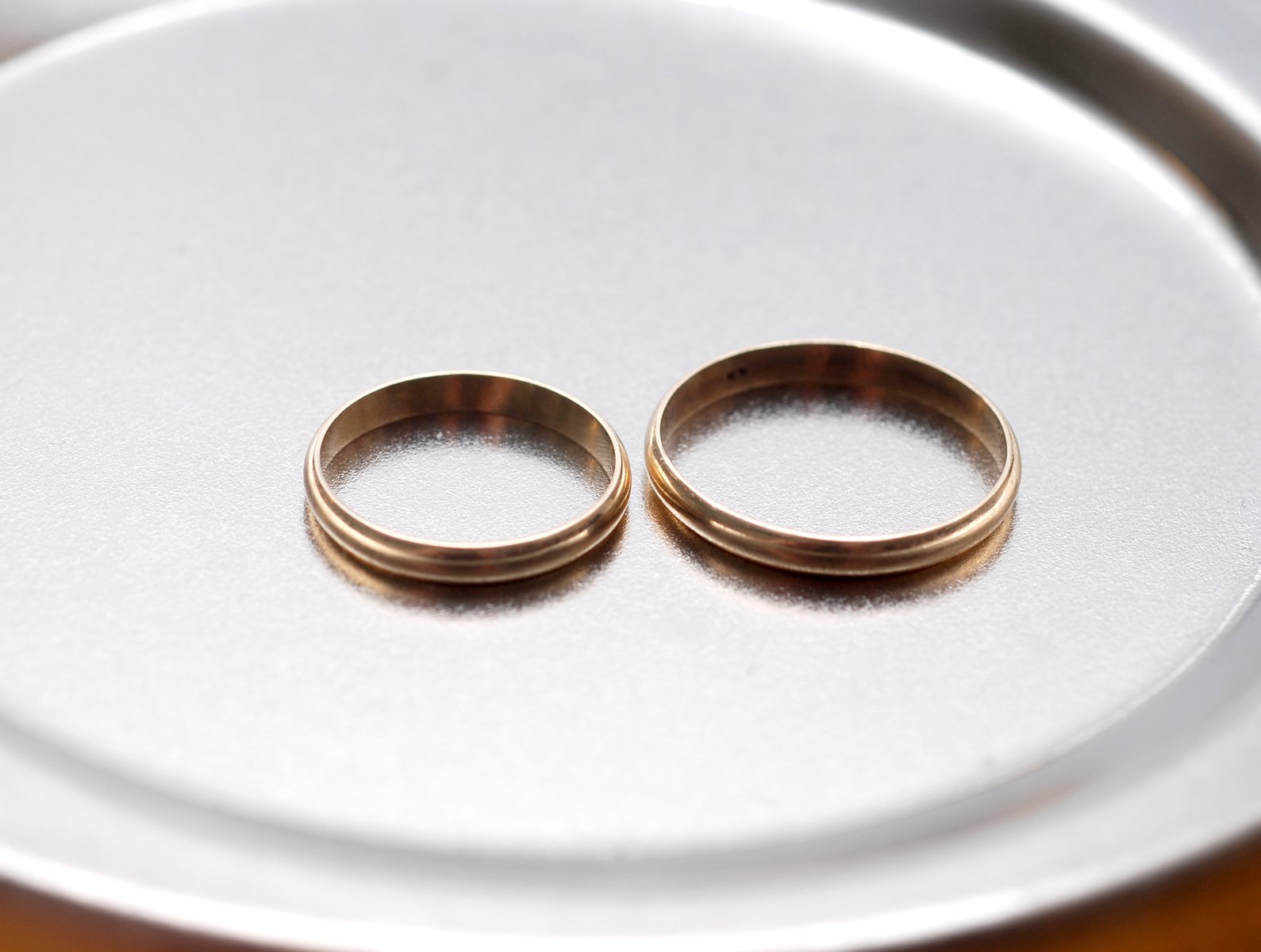two wedding rings sitting on top of a white plate