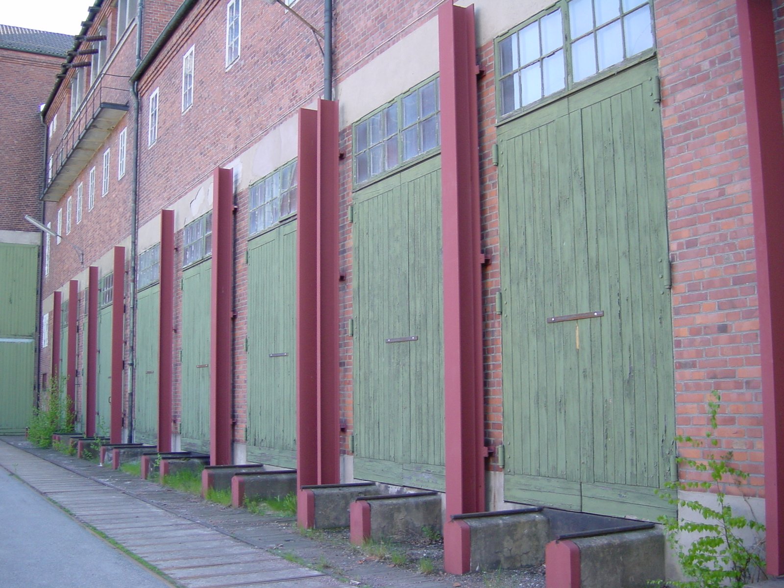 an old fashioned red and green building with a fire hydrant