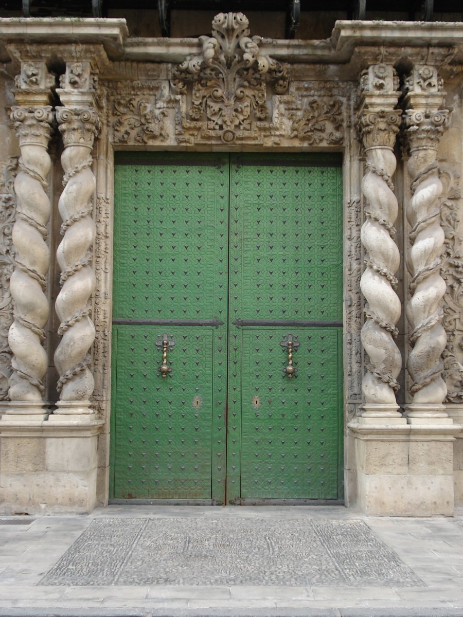 a green door and a large door with sculptures