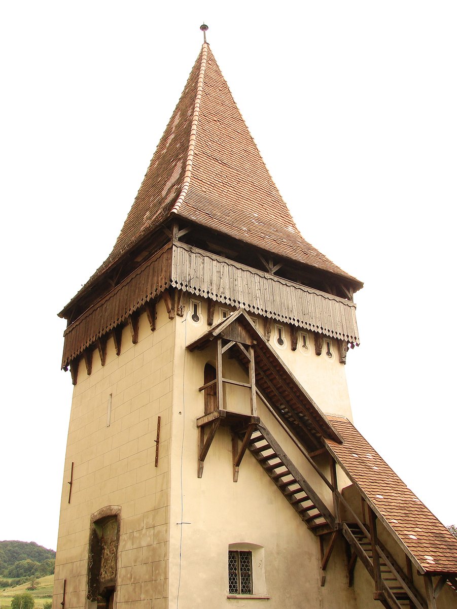 the tower is made of stone with a wooden staircase leading up to it
