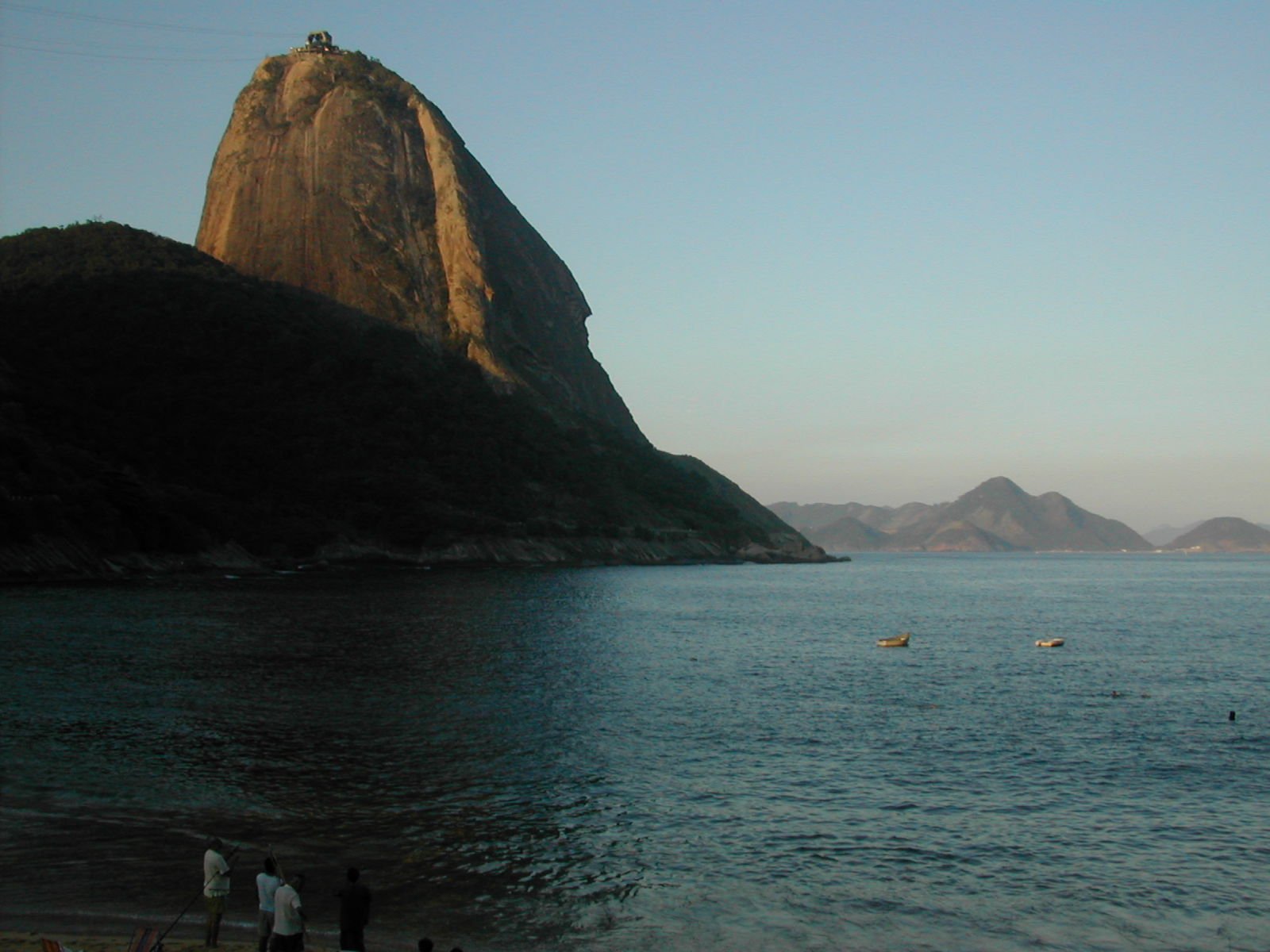 a rocky landscape by the sea with two boats in the water