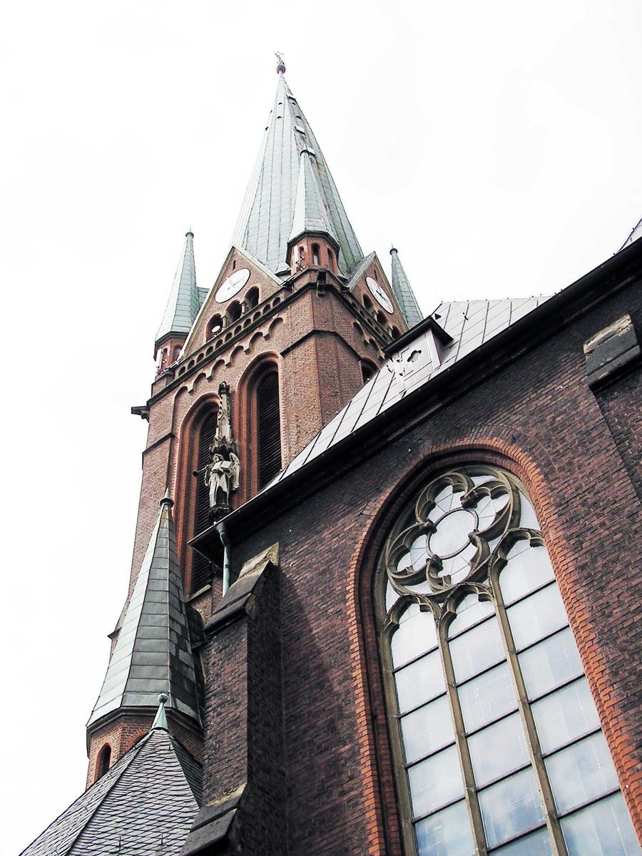 a tall brown church with three steeples on each corner