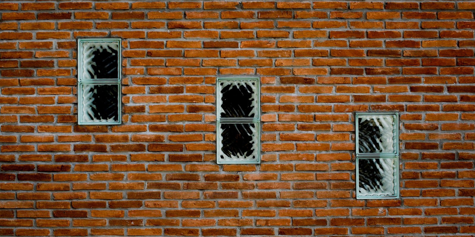 an orange brick building with windows and three different color bars