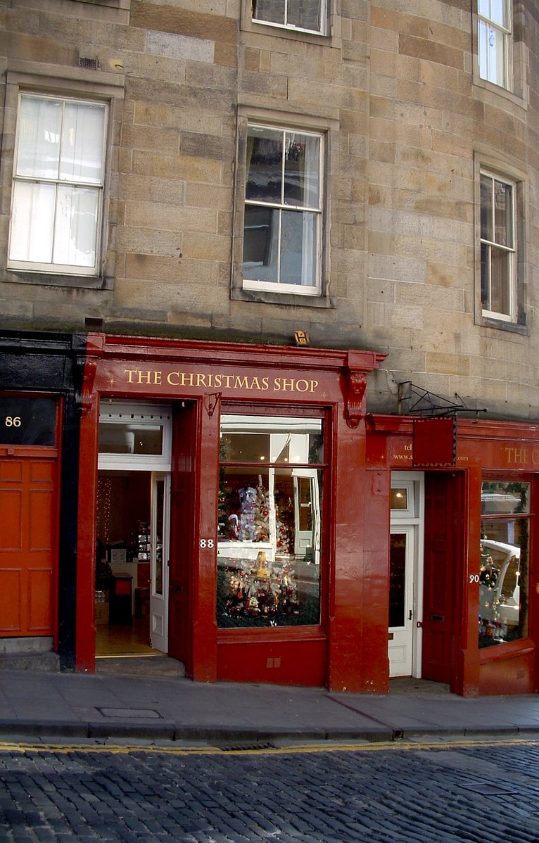 red storefronts in front of a stone building