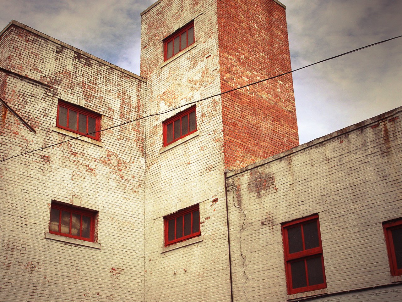 the side of an old red brick building with windows