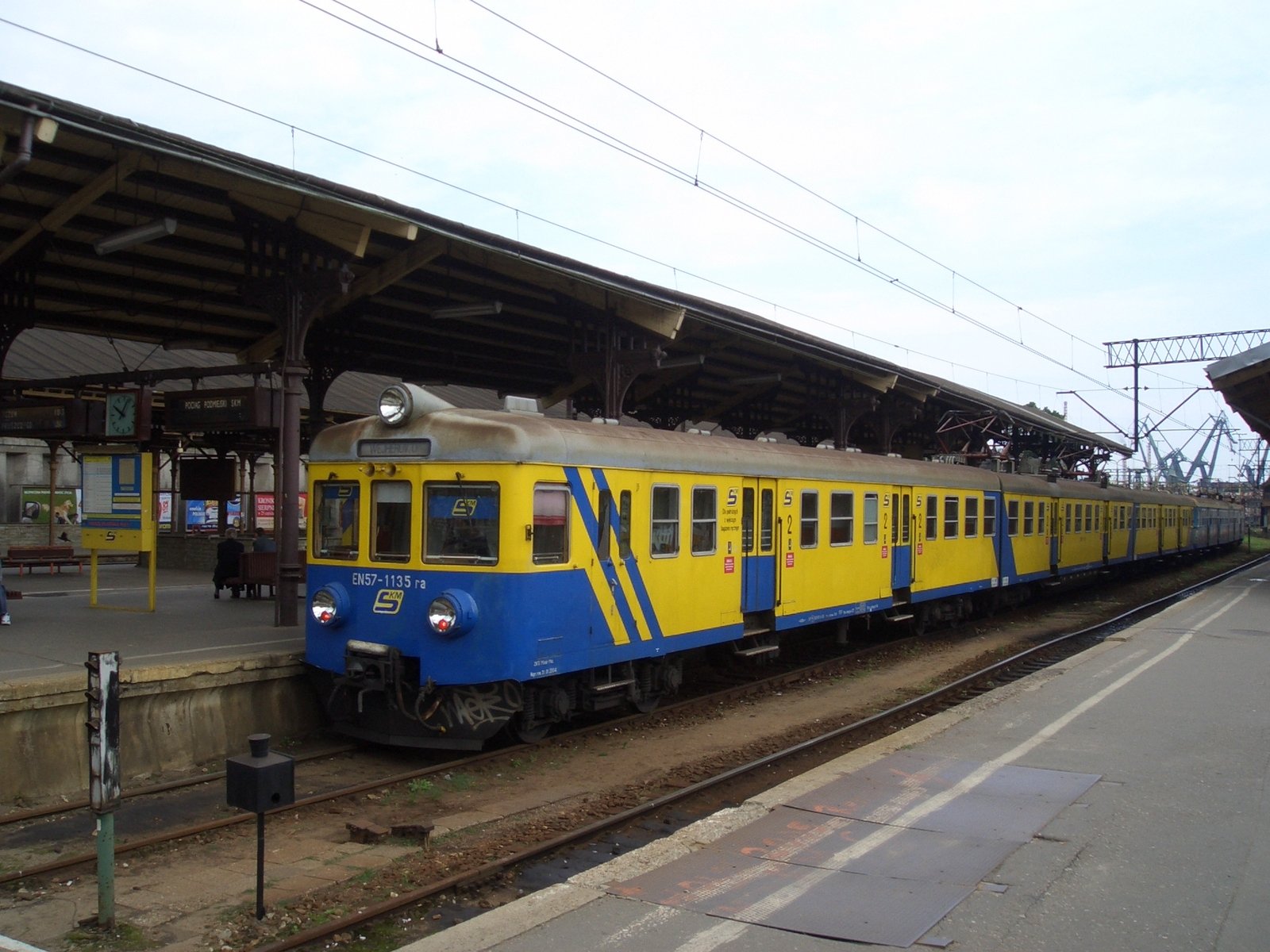 a train on tracks next to a passenger loading area