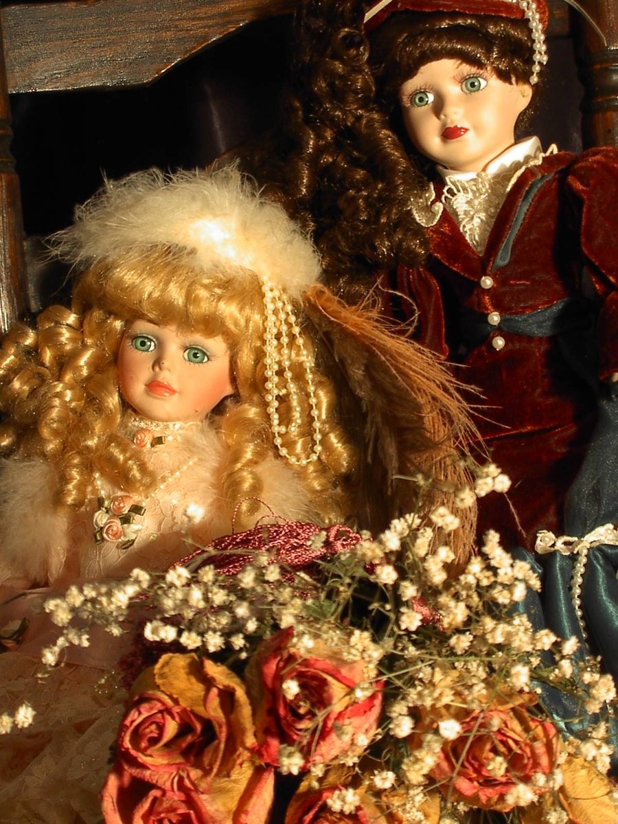 a few dolls dressed as victorian ladies next to each other
