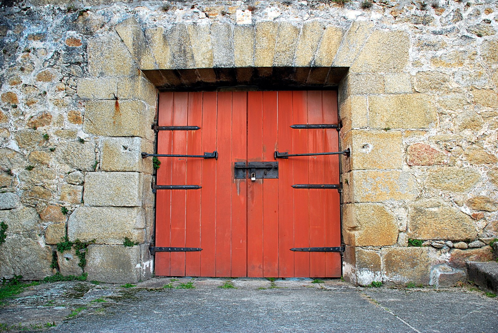 an old red wooden door on a building