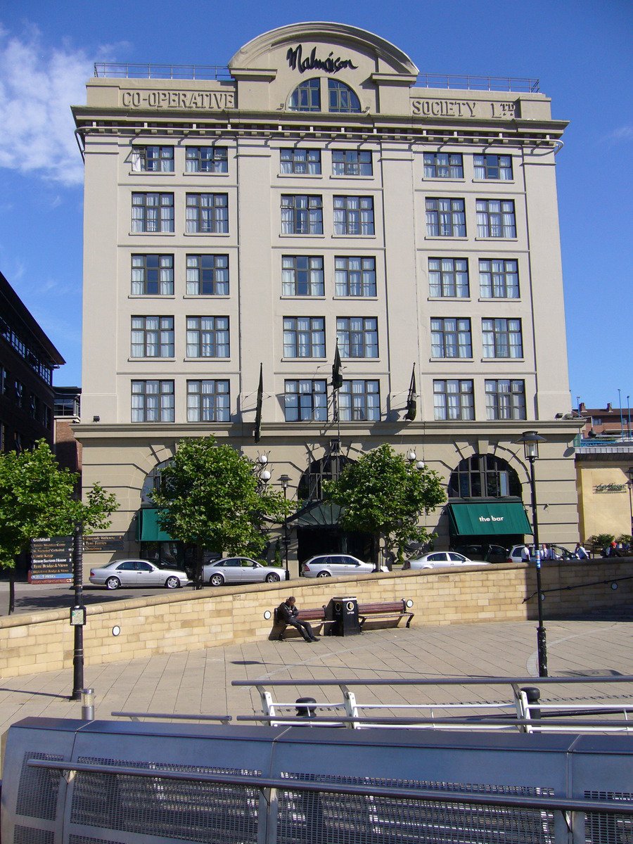 a large, grey building with cars in front of it