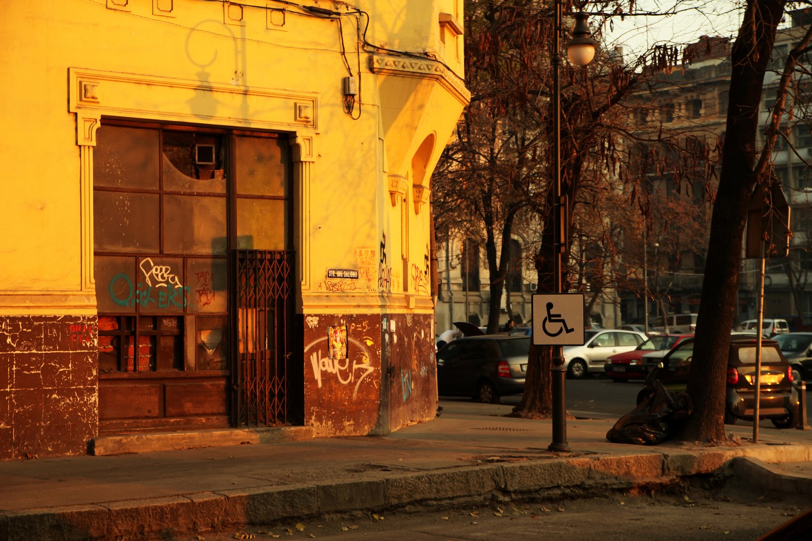 a side walk with many cars parked along it