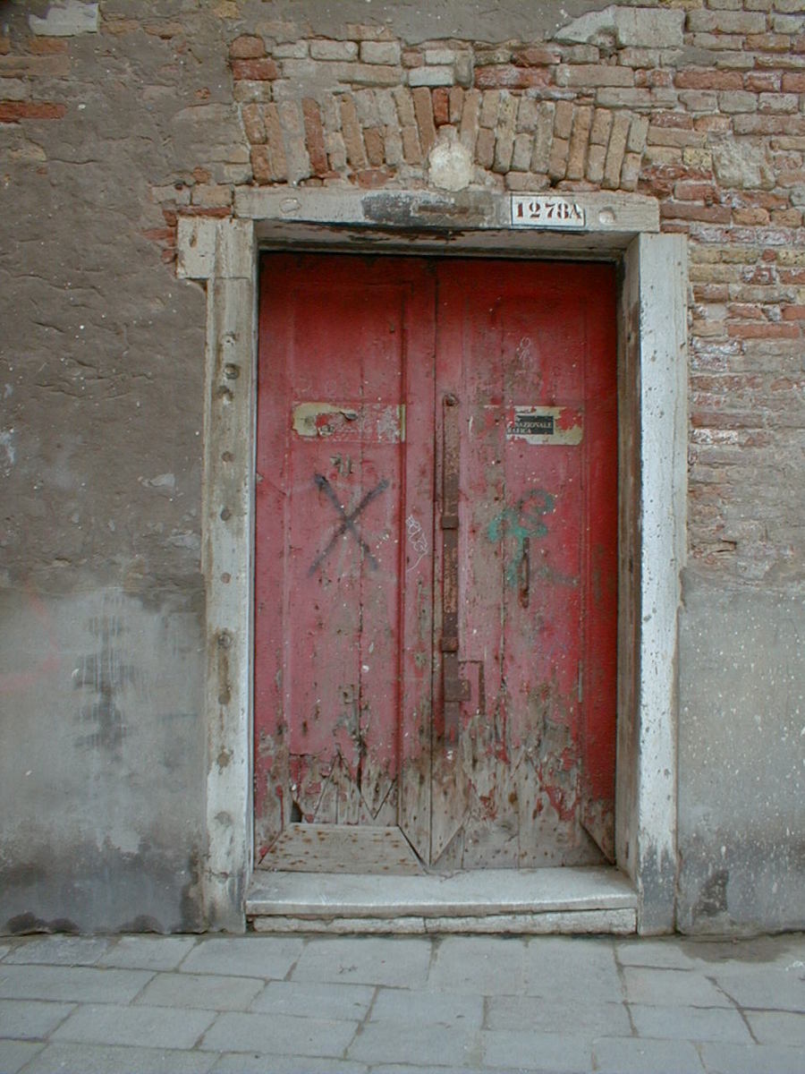 a brick building with two double door and a sign on the front