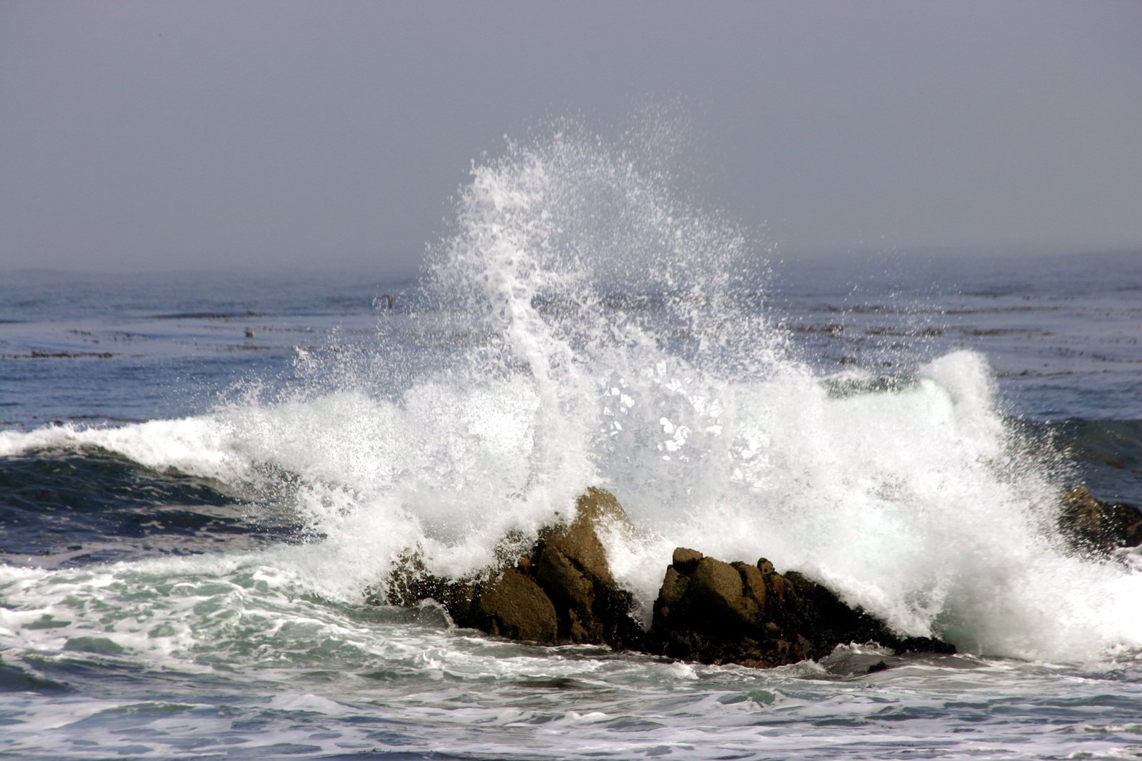 the waves are coming towards the rocky shore