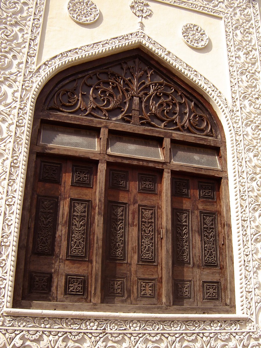 the wood door of an islamic building has a carving work