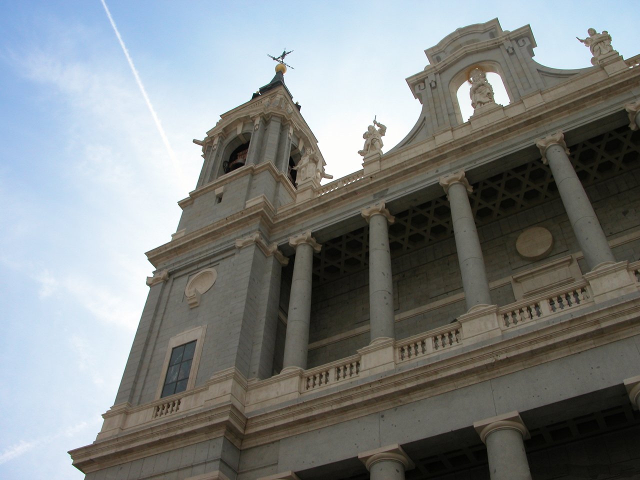 a large building with pillars and a clock on it's side