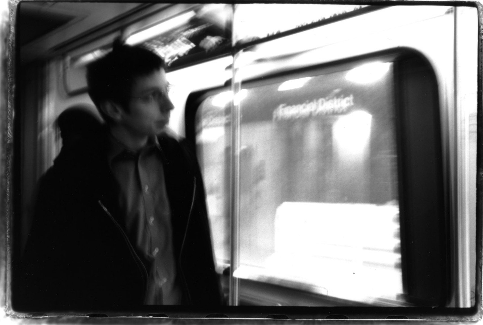 black and white pograph of man looking at train window