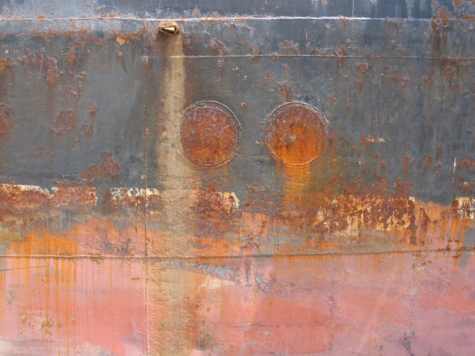 a rusted metal panel on the side of a building