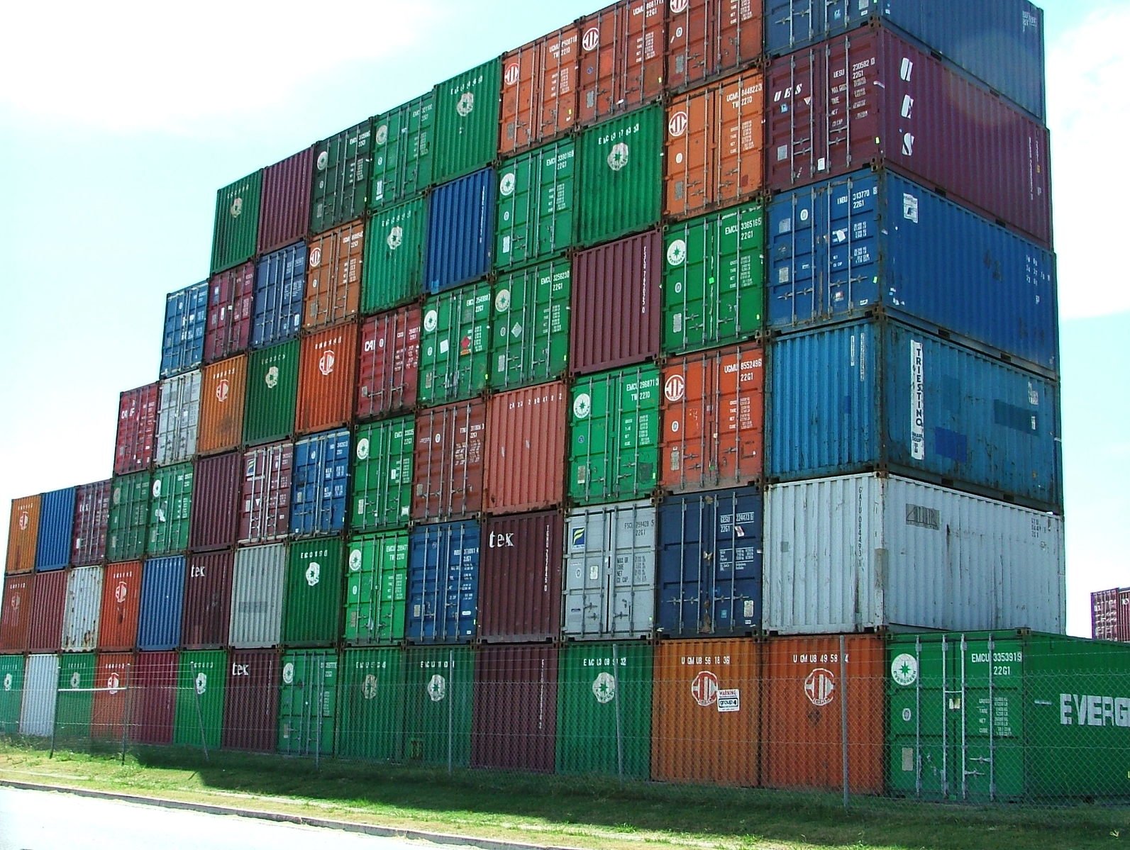 several stacked up shipping containers in a container yard