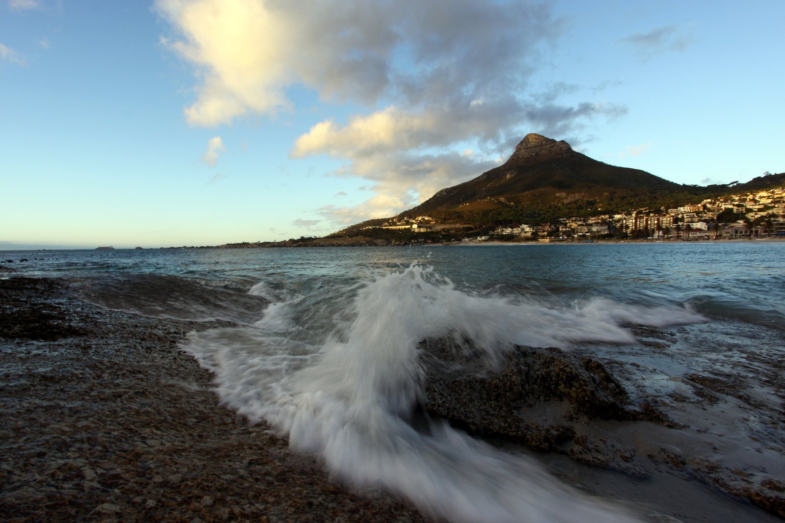 a large wave crashing on a rocky shore