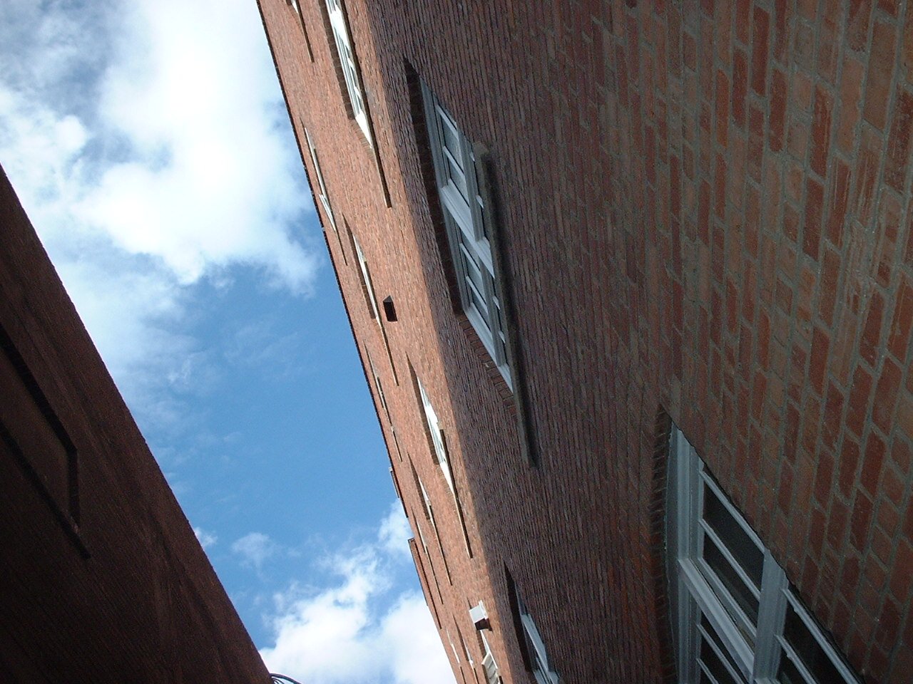 an upward view of a tall brick building with windows