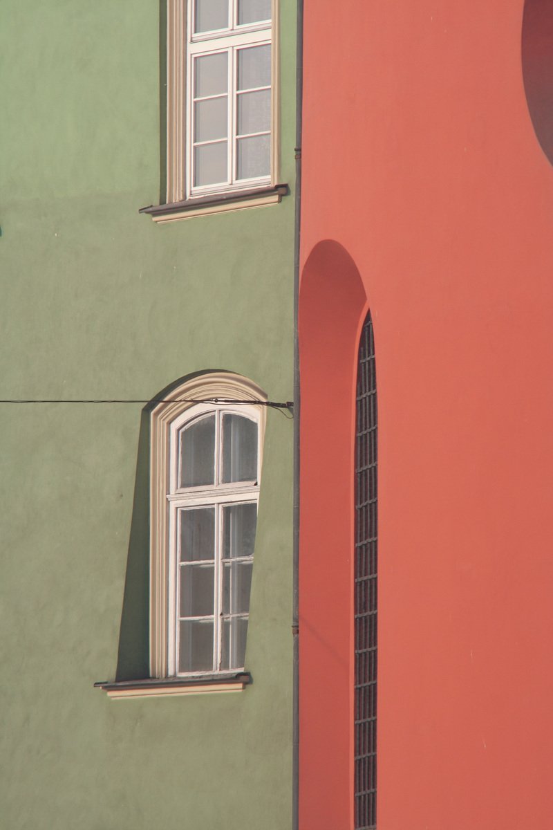 a view of two windows on a multi - color building