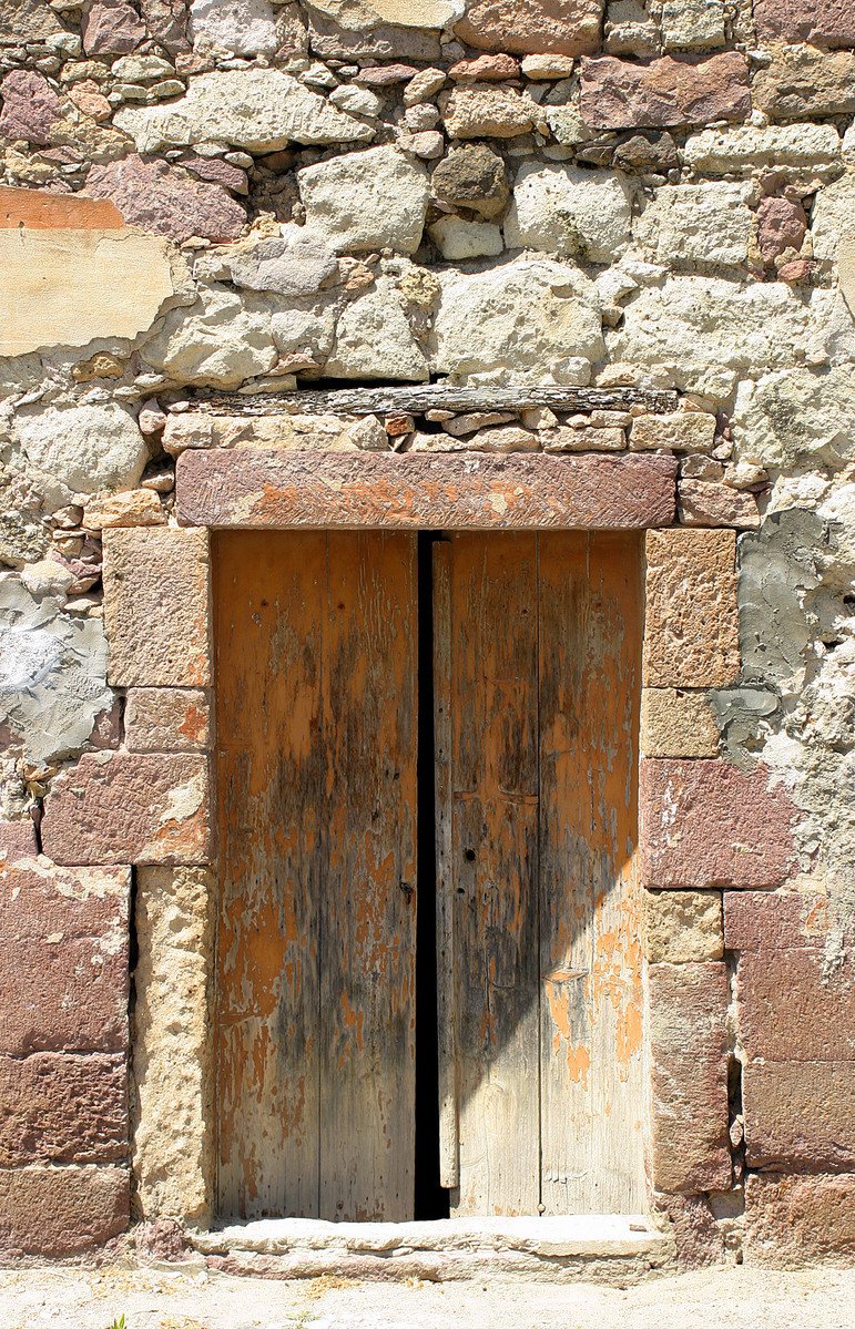 a very large old door and window of an ancient stone building