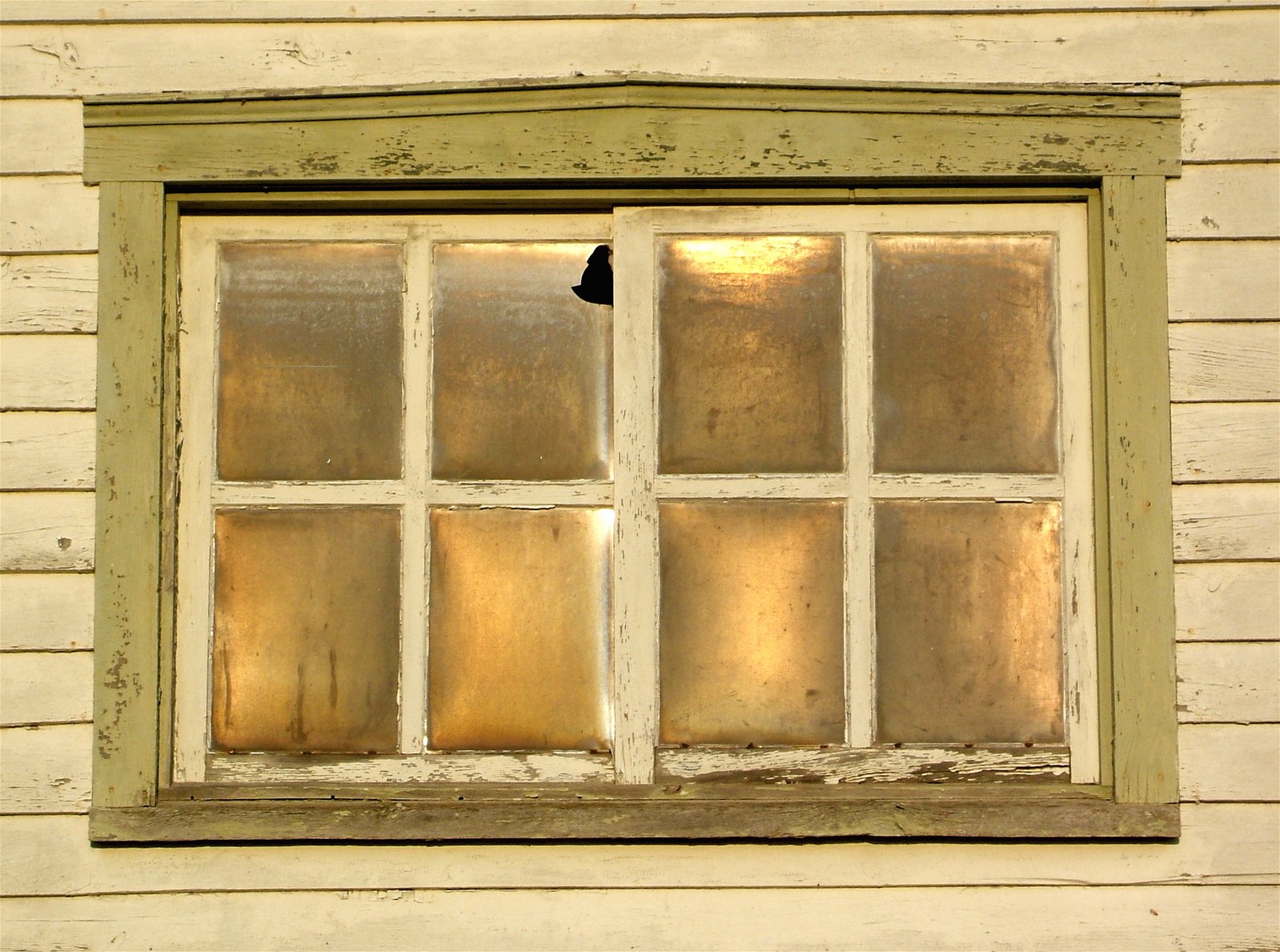 a broken window in the corner of a house