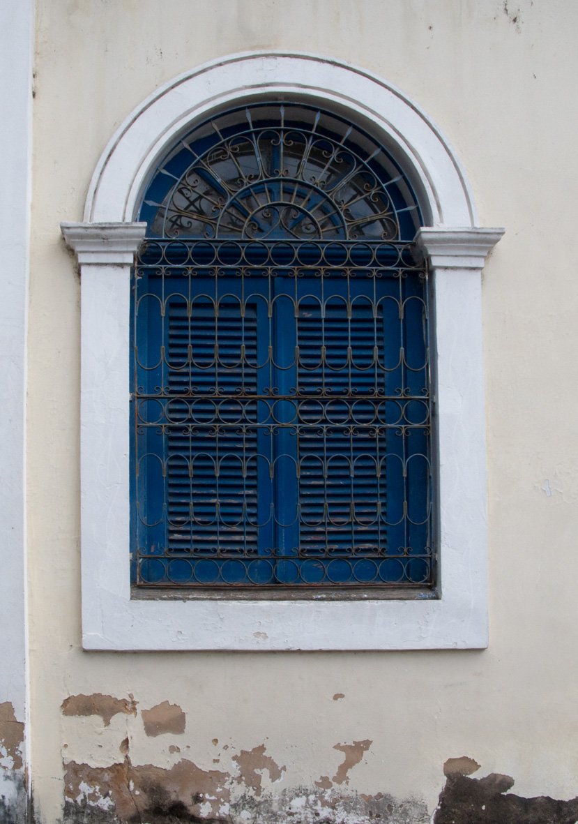 the window on the side of a building has bars in it