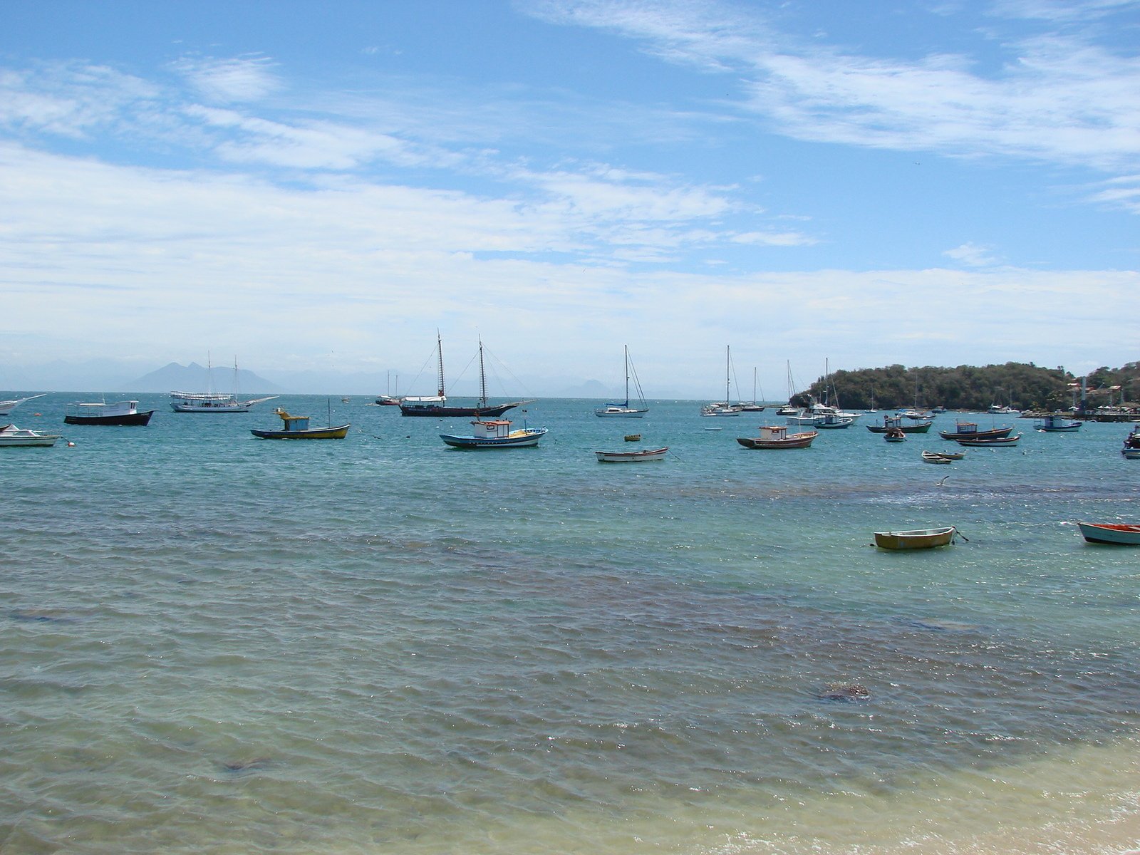 several boats in the ocean on the beach
