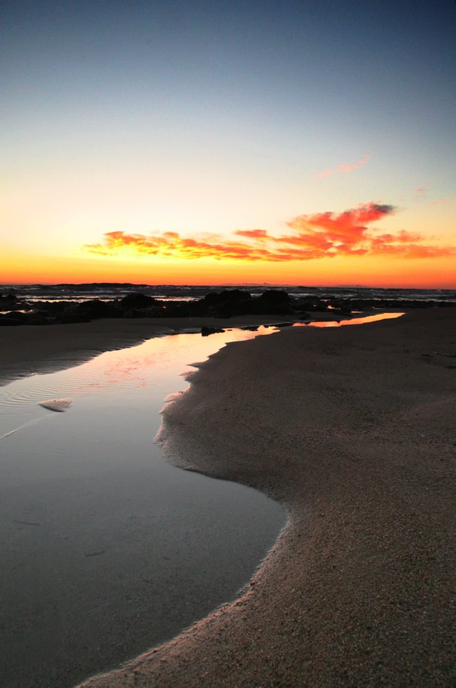 the shore line of a beach is shown in silhouette